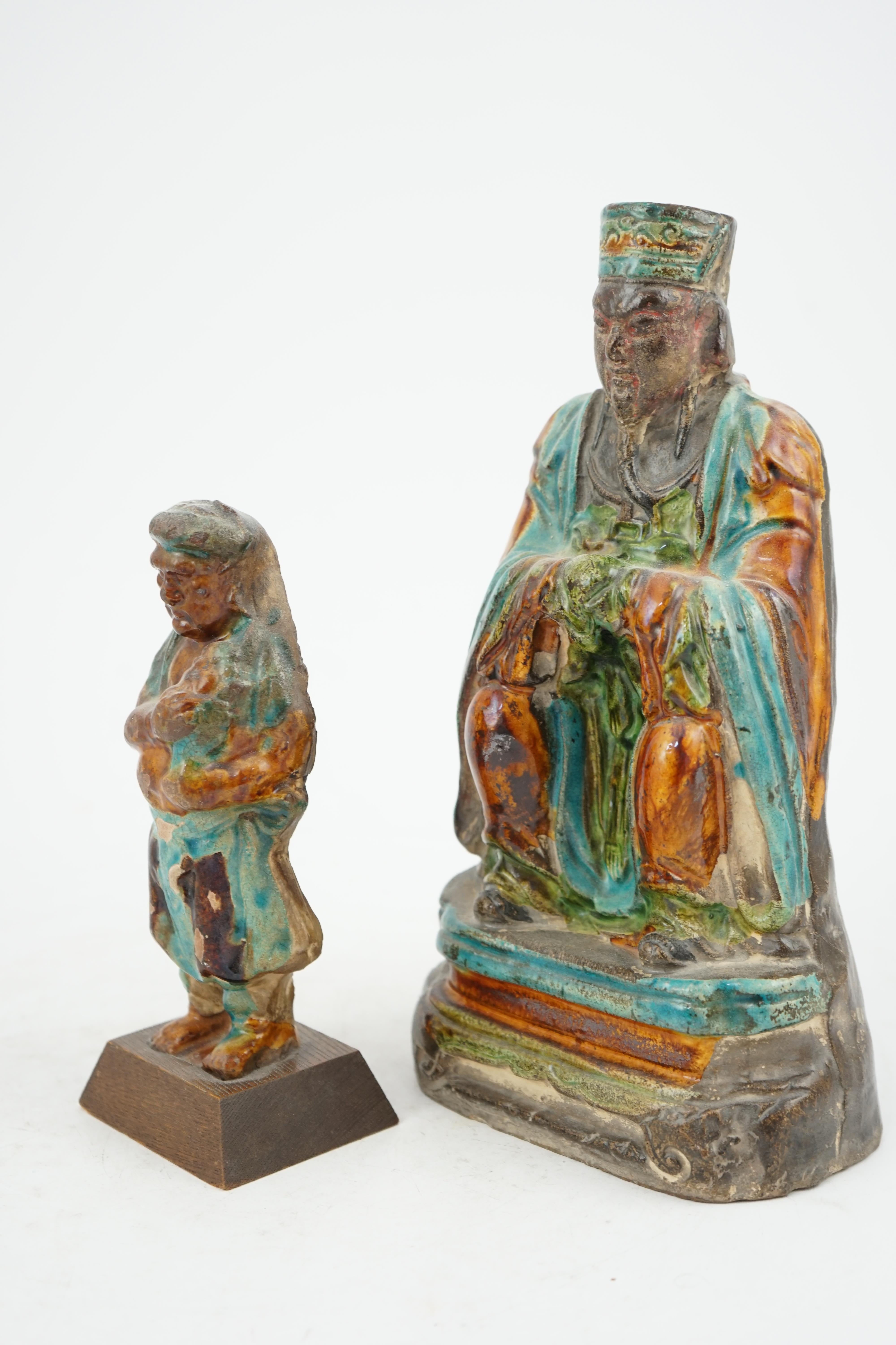 Two Chinese sancai glazed figures of a seated dignitary and a standing attendant, Ming dynasty